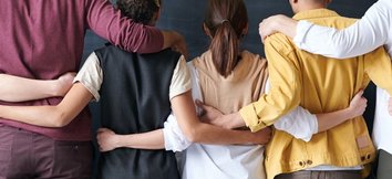 People with their arms around each other's shoulders